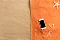 Top view of sandy beach with towel frame. Smartphone with accessories on sand background Royalty Free Stock Photo