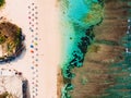 Top view of sandy beach with turquoise ocean and bright colorful umbrellas, aerial shot Royalty Free Stock Photo