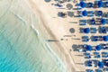 Top view of sandy beach with turquoise sea water and colorful blue umbrellas on the Sunset, Islands of Sardinia in Italy Royalty Free Stock Photo