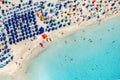 Top view of sandy beach with turquoise sea water and colorful umbrellas, Sardinia in Italy, aerial drone shot Royalty Free Stock Photo