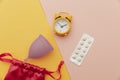 Top view of sanitary cup with pain relief pills and an alarm clock Royalty Free Stock Photo