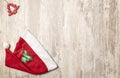 Top view of a Santa Claus hat and a red little wooden Christmas tree on the top left corner Royalty Free Stock Photo