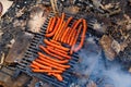 Top view of sausages barbequing on an old rusty brazier