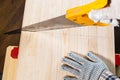 Top view of sawing solid wood board with hand saw