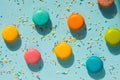 Top view of scattered colorful macaroons and sugar sprinkles over blue background. Abstract food background. Royalty Free Stock Photo