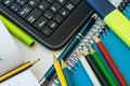Top view school supplies, laptop tablet keyboard, multicolored pencils, highlighter, pen, opened mathematics workbook with formula