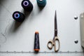 Top view of scissors and skeins of thread on a white table with markings. Sewing industry. Manufacturing of clothes Royalty Free Stock Photo
