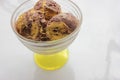Scoops of orange and chocolate ice cream in a glass dessert bowl on white background with copy space. Selective focus