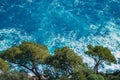 Top view of sea waves hitting rocks on the beach with turquoise blue sea water. green trees on cliff. seascape coastline in Nice