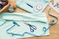 top view of seamstress workplace on table with fabric, scissors, needles, measuring tape