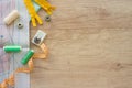 Top view on seamstress workspace with threads and sewing accessories and tools in green and yellow colours, on wooden background Royalty Free Stock Photo