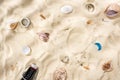 Top view of seashells, bottle caps, scattered cigarette butts and glass bottle on sand. Royalty Free Stock Photo