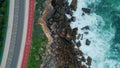 Top view seaside road over stormy ocean splashing on stones. Aerial sea foaming Royalty Free Stock Photo