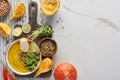 Top view of seasonal mashed pumpkin soup on wooden cutting board with ingredients on marble surface. Royalty Free Stock Photo