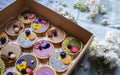 Top view of selection of colorful and delicious cake desserts in box on table.