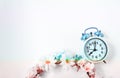 Top view selective focus vintage alarm clock  with beautiful bouquet flowers  on white background. Love anniversary, dating and Royalty Free Stock Photo