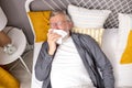 Top view on senior man lying on bed with handkerchief feeling ill, getting flu Royalty Free Stock Photo