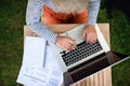 Top view of senior woman with laptop working outdoors in garden, home office concept. Royalty Free Stock Photo