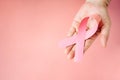 Top view of senior woman hand supports Breast Cancer Day by holding Pink Ribbon Breast Cancer Awareness with copy space Royalty Free Stock Photo