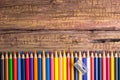 Top view of a set of colored pencils on wooden background with s Royalty Free Stock Photo