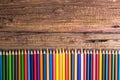 Top view of a set of colored pencils on wooden background with s Royalty Free Stock Photo