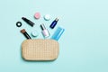 Top view of set of make up and skin care products spilling out of cosmetics bag on blue background. Beauty concept Royalty Free Stock Photo