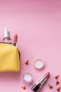 Top view of set of make up and skin care products spilling out of cosmetics bag on pink background. Beauty concept Royalty Free Stock Photo