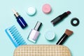 Top view of set of make up and skin care products spilling out of cosmetics bag on blue background. Beauty concept Royalty Free Stock Photo