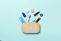 Top view of set of make up and skin care products spilling out of cosmetics bag on blue background. Beauty concept Royalty Free Stock Photo