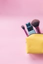 Top view of set of make up and skin care products spilling out of cosmetics bag on pink background. Beauty concept Royalty Free Stock Photo