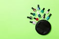 Top view of the set of nail polishes and bright gel varnishes fallen out of cosmetics bag with copy space on green background. Royalty Free Stock Photo