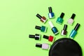 Top view of the set of nail polishes and bright gel varnishes fallen out of cosmetics bag with copy space on green background. Royalty Free Stock Photo