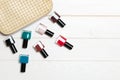 Top view of the set of nail polishes and bright gel varnishes fallen out of cosmetics bag with copy space on wooden background. Royalty Free Stock Photo