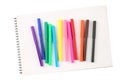 Top view of a set of twelve colorful felt tip markers on a blank scetchbook isolated on white background Royalty Free Stock Photo