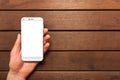 A top view of a set of wired earbud headphones and mobile phone blank template lying on a rustic wooden table. mockup image Royalty Free Stock Photo