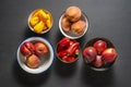 Top view of several assorted bowls of nectarines, peaches, and red and yellow bell peppers Royalty Free Stock Photo