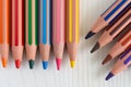 Top view of several colored pencils arranged vertically and diagonally on white wooden background Royalty Free Stock Photo