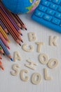 Top view of several diagonal colored pencils, world ball and blue calculator, with the words back to school unlinked, Royalty Free Stock Photo