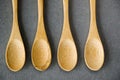 Top view of several empty wooden spoons on the gray background, wooden dishware, and tableware