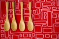 Top view of several empty wooden spoons on a red background, wooden dishware, and tableware