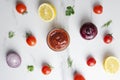 Top view of several ingredients for tomato sauce on white marble table.Abstract and artistic composition of vegetables and spieces Royalty Free Stock Photo