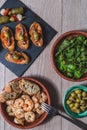 Top view several plates and casseroles with traditional spanish tapas food served on a wooden table Royalty Free Stock Photo