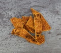 Top view of several slices of duck jerky on a gray mottled background
