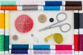 Sewing kit colorful threads frame top view white linen background Royalty Free Stock Photo