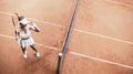 Top view of attractive young woman tennis player looking forward on clay tennis court