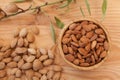 Top view of shell and peeled almonds in wooden bowl with a tree brunch Royalty Free Stock Photo