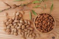 Top view of shell and peeled almonds in wooden bowl with a tree brunch Royalty Free Stock Photo