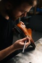 Top view of shoemaker painting heel and sole of light brown leather shoes with brush during restoration working. Royalty Free Stock Photo