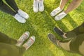 Top view Image of shoes of young teenagers girls standing in a circle on the grass of a park. Enjoying a happy moment and a