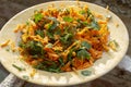 Top view shoot of fresh looking carrot salad on plate under beautiful sunlight